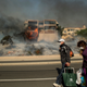 An apocalyptic scene as a couple evacuate their Ventura neighborhood. (Image: AP)